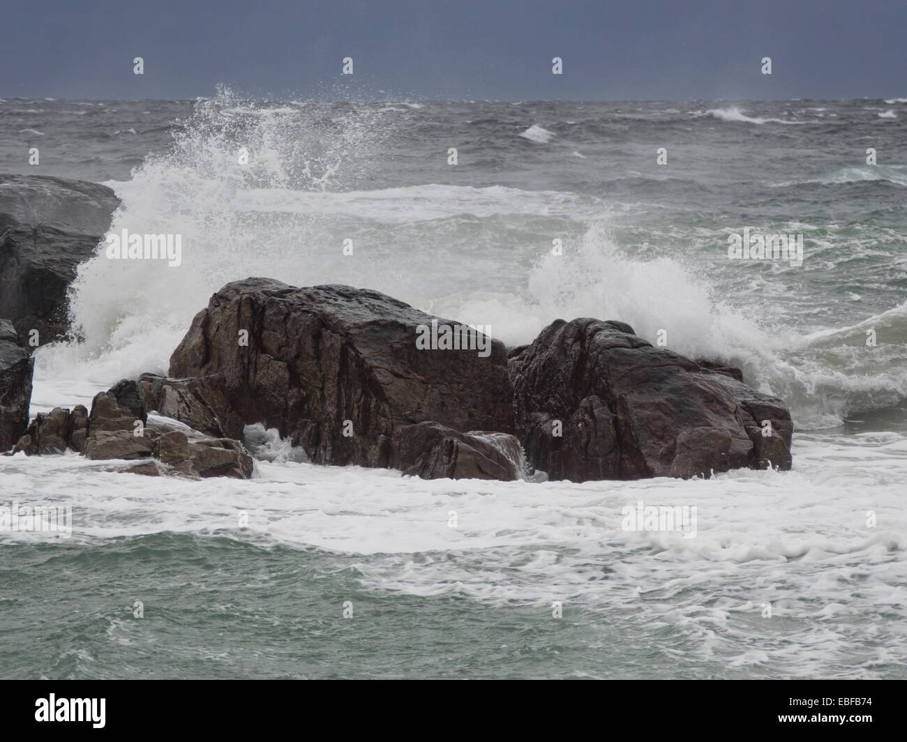 A dark day with autumn or winter storms on Jaeren, west coast of Norway near Stavanger waves breaking over rocks and beach Stock Photo
