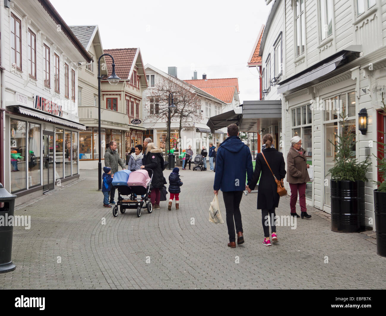 Busy pedestrian only street in the center of the small Norwegian town Egersund, wooden paneled  traditional houses and shops Stock Photo