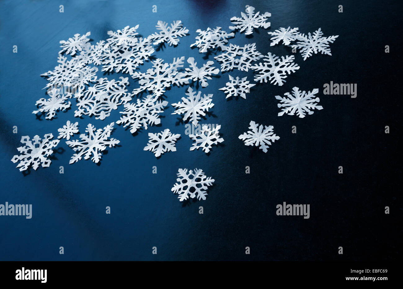 White paper snowflakes on dark blue background Stock Photo - Alamy