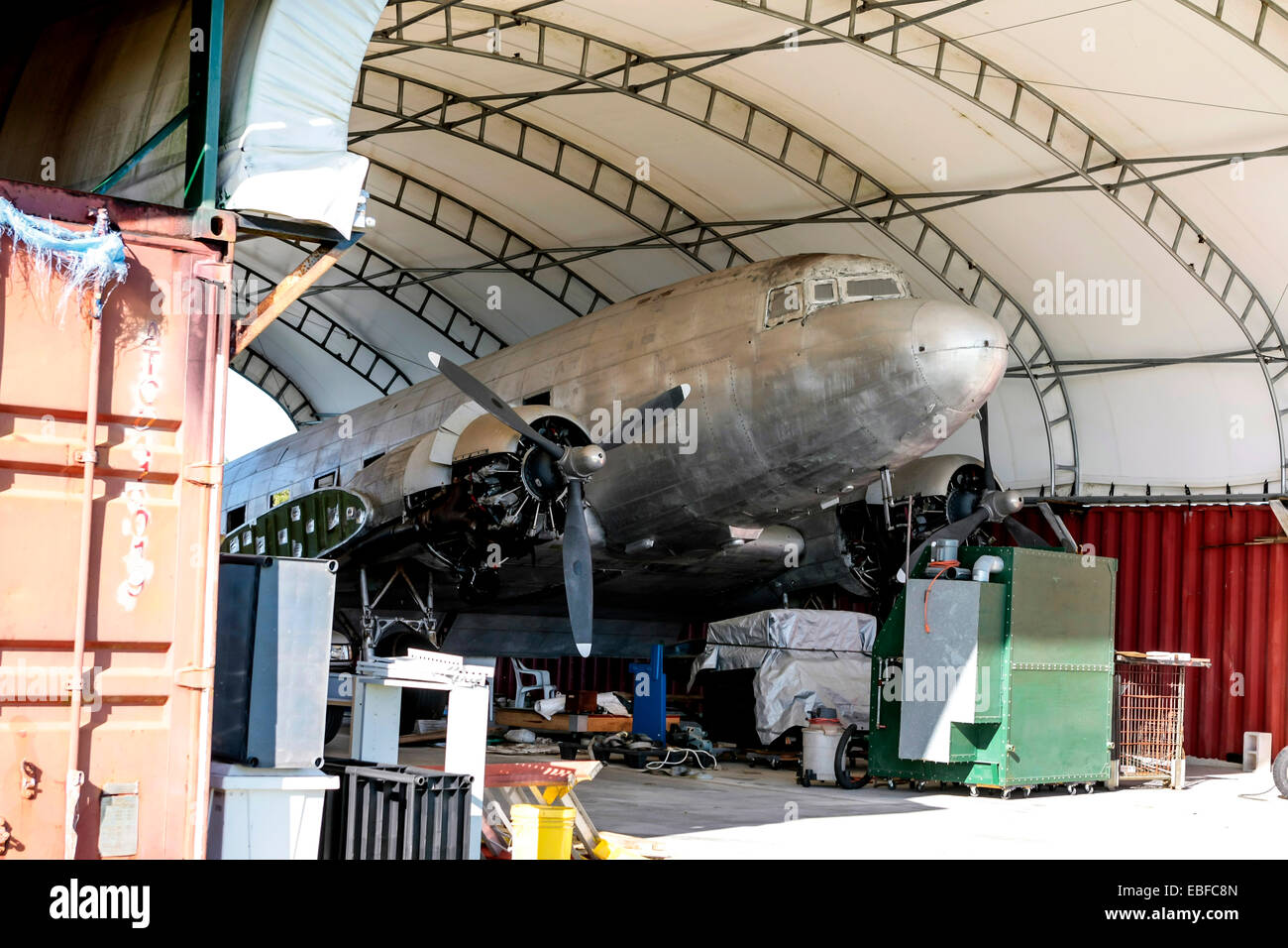 A Douglas DC-3 being restored under an open hangar in Florida Stock Photo