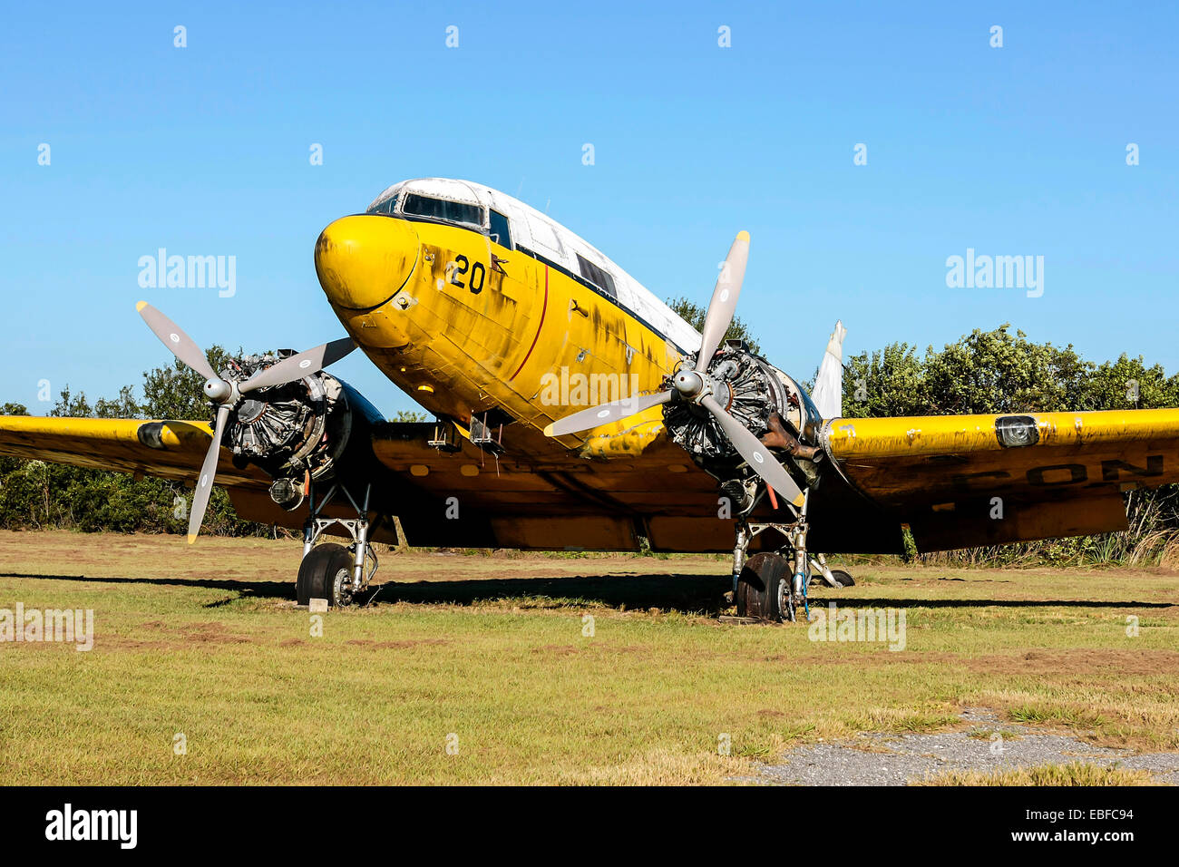 An old yellow painted Douglas DC-3 awaiting restoration or scrapping at an aviation junkyard in Florida Stock Photo