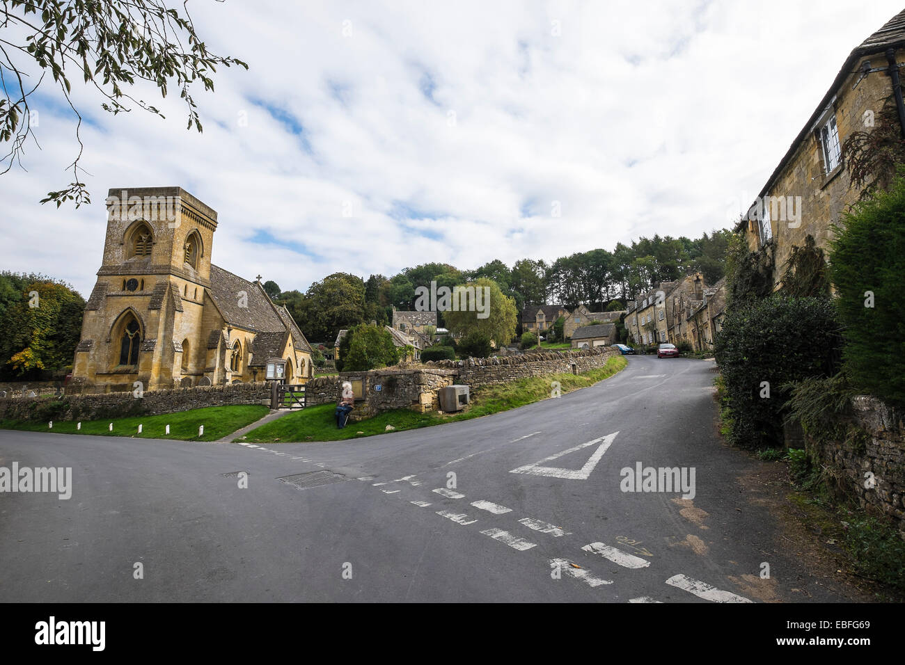 Tourist resting at St Barnabas Church Snowshill village The Cotswolds Gloucestershire England Stock Photo