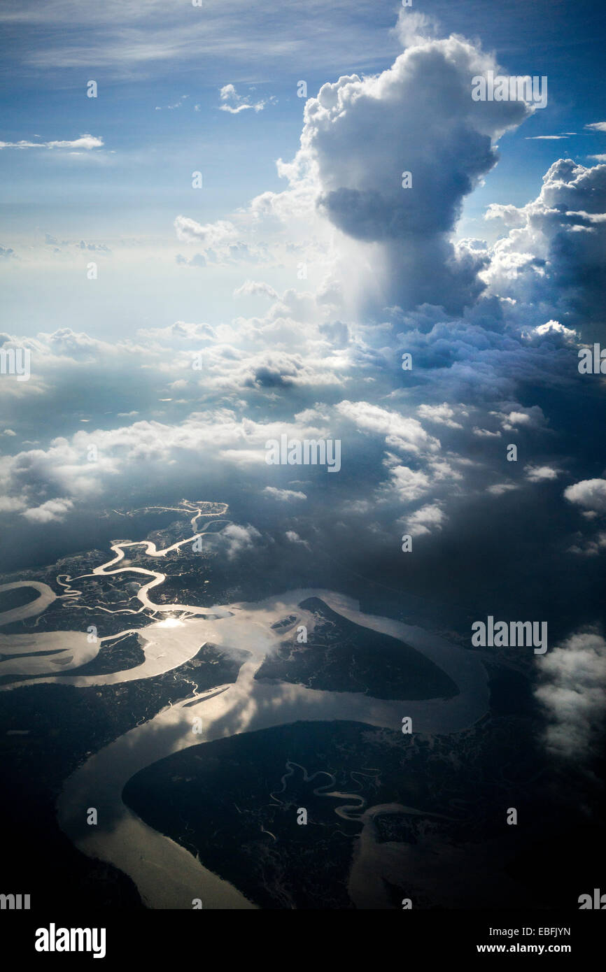 High altitude clouds, cumulus clouds, in color, dramatic photograph. Twisting rivers and streams below in surface. Stock Photo