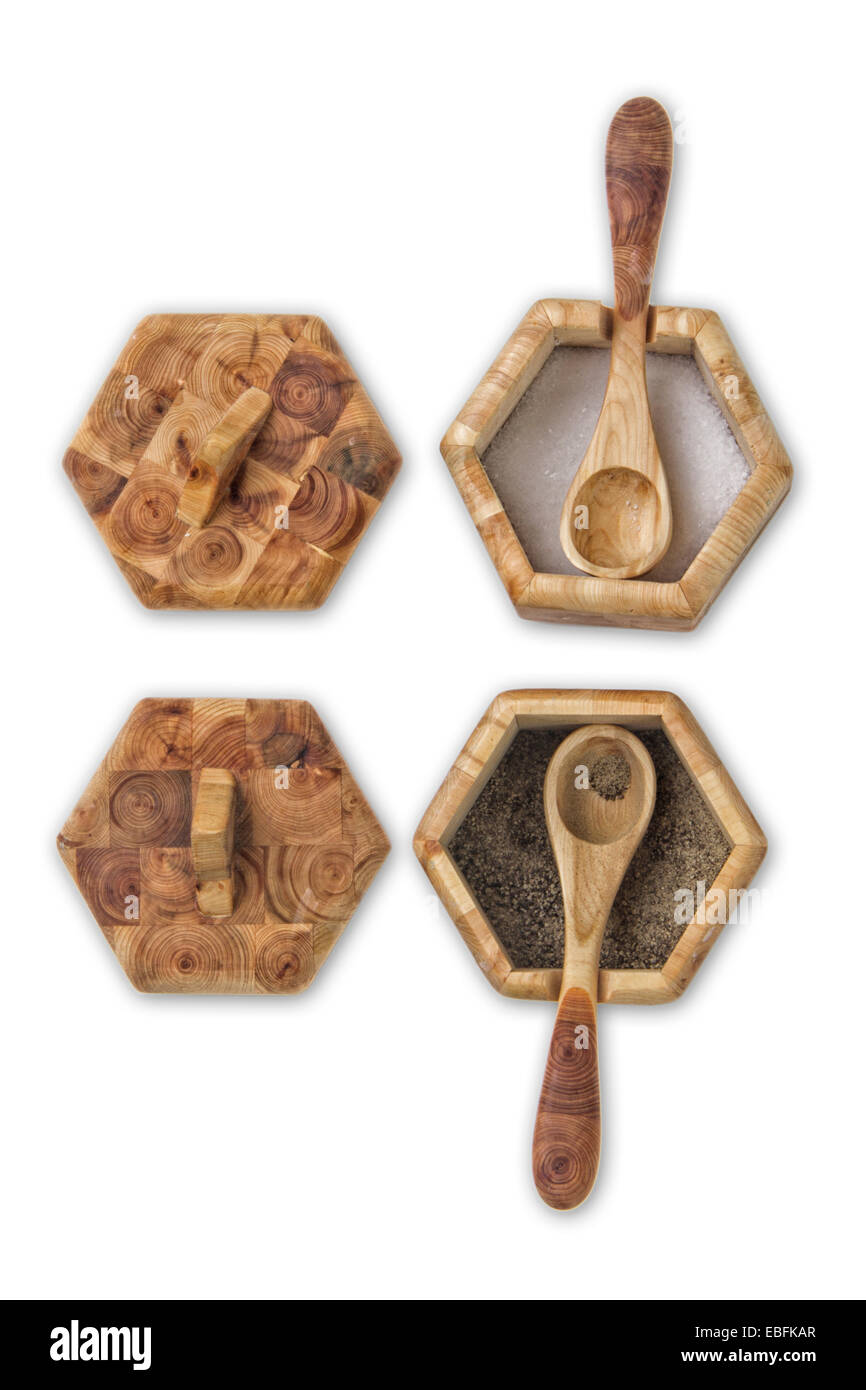 Two wooden condiment pots with spoons and lids on a flagstone floor