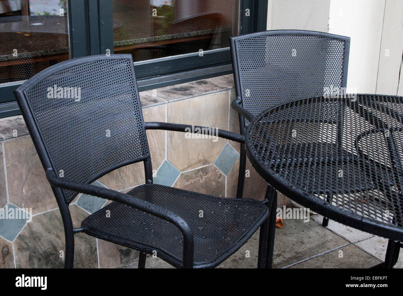 Cafe table and chairs in the rain outside of a Peet's in Berkeley, California. Stock Photo