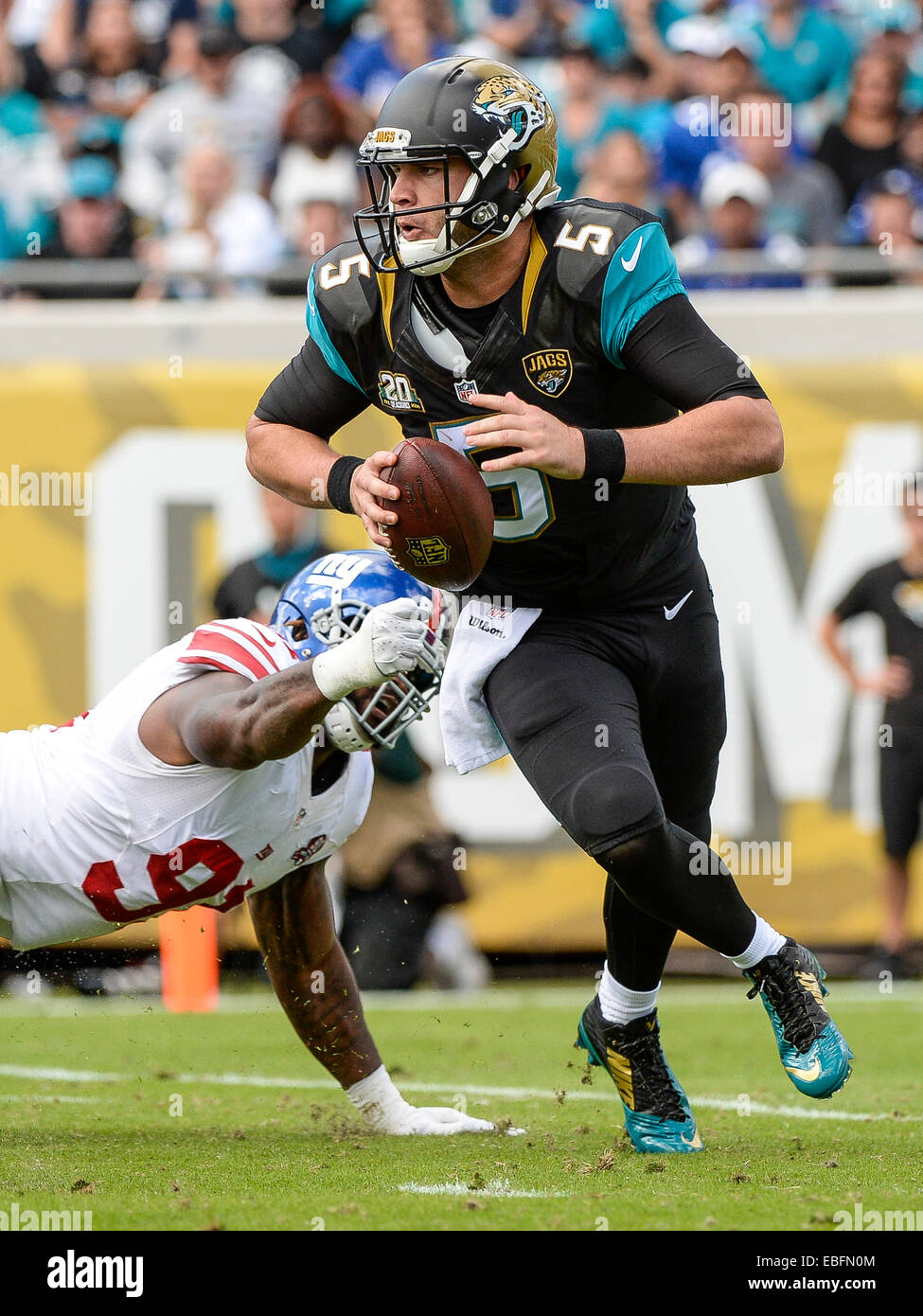 Jacksonville, FL, USA. 30th Nov, 2014. Jacksonville Jaguars quarterback Blake Bortles (5) scrambles from New York Giants defensive end Robert Ayers (91) during 1st half NFL game action between the New York Giants and the Jacksonville Jaguars at EverBank Field in Jacksonville, FL © csm/Alamy Live News Stock Photo