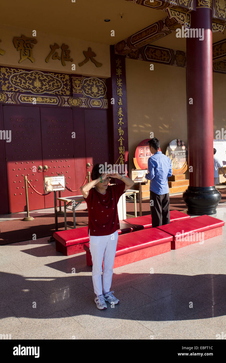 adult woman, adult, woman, at prayer, praying, entrance, Main Hall, Hsi Lai Temple, city of Hacienda Heights, Los Angeles County, California Stock Photo