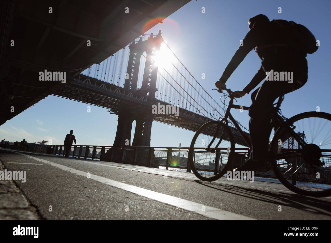 Cyclist and walker on the East River Esplanade New York Manhattan Bridge Stock Photo