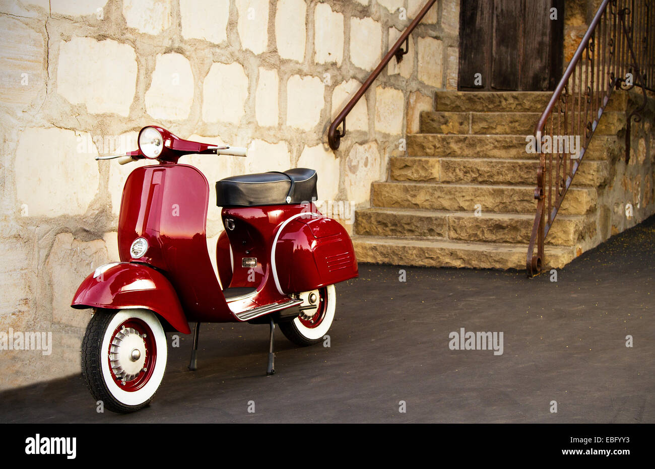 1968 red Vespa scooter outside a rustic building Stock Photo