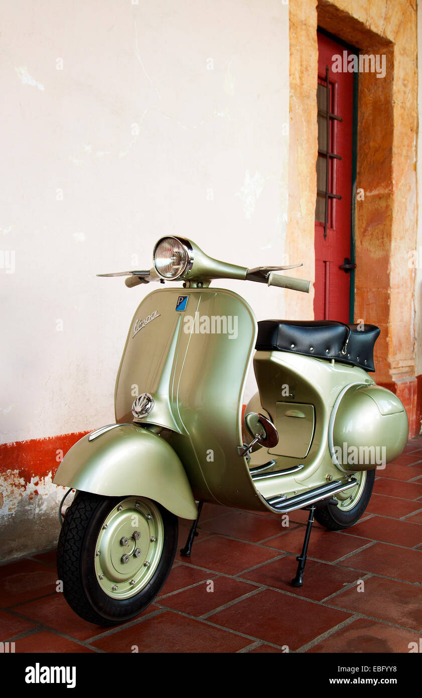 1958 green vespa vintage scooter outside a rustic building Stock Photo