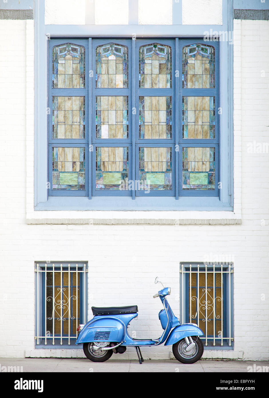 Profile of blue vespa super sport in front of an old church Stock Photo