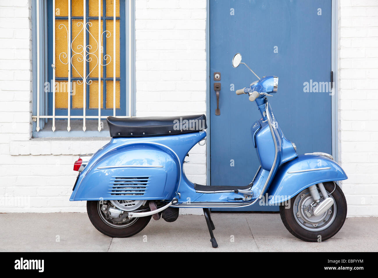 Profile of light blue Vespa scooter infront of building Stock Photo