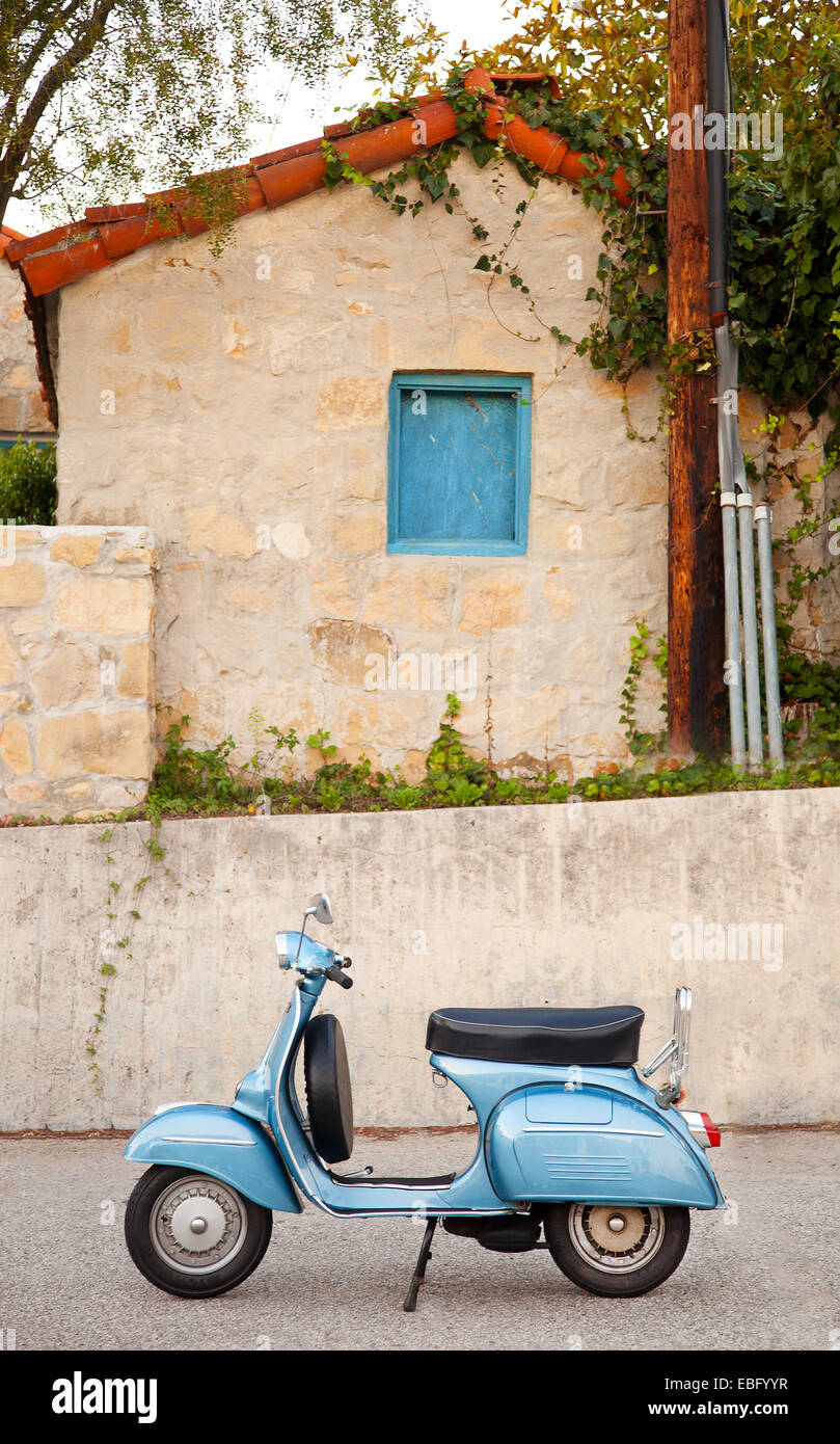 Profile of light blue restored Vespa scooter in front of building Stock Photo
