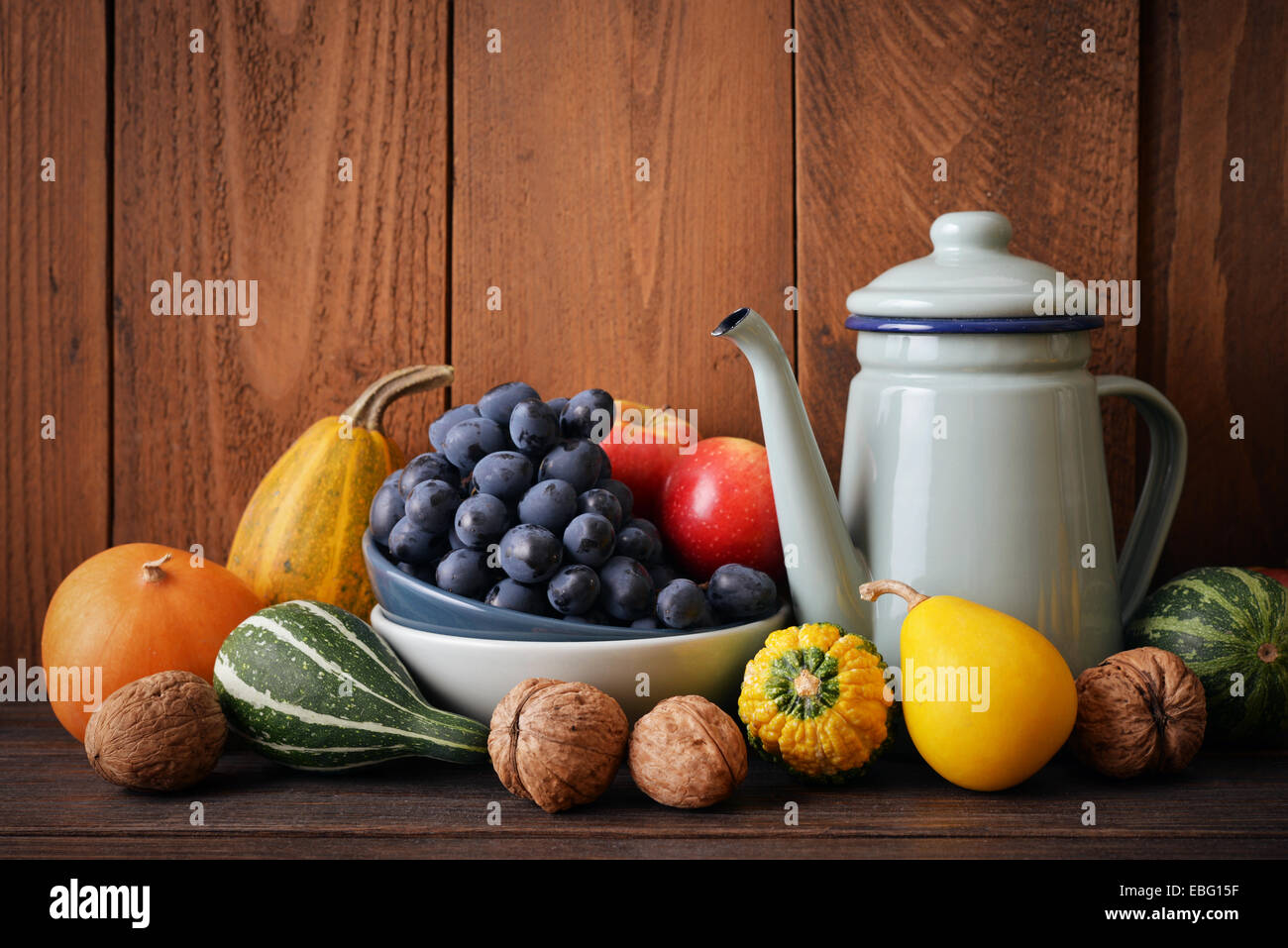 Fresh pumpkins with fruits and vintage kettle on wooden background ...