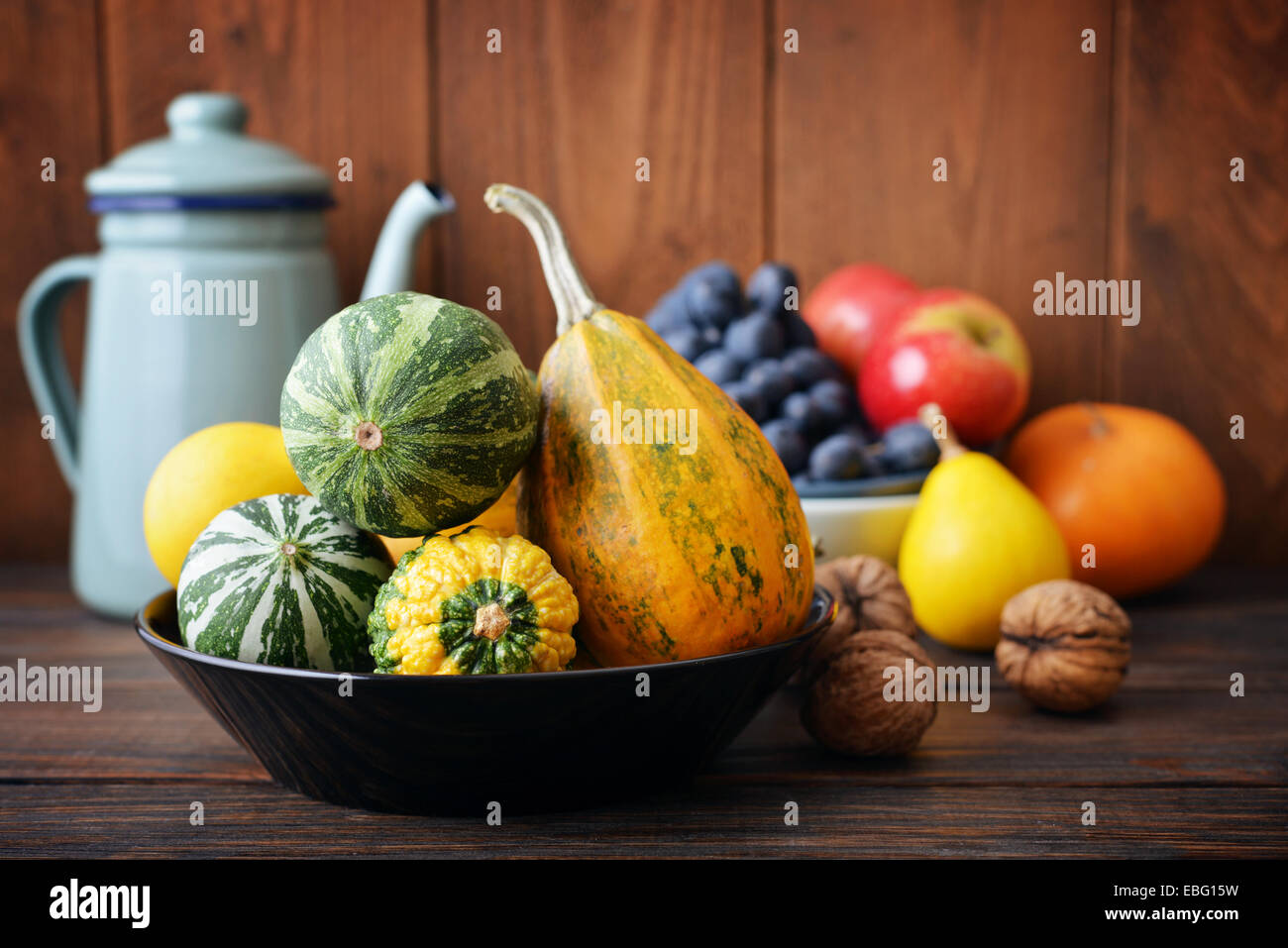 Fresh pumpkins with fruits and vintage kettle on wooden background ...