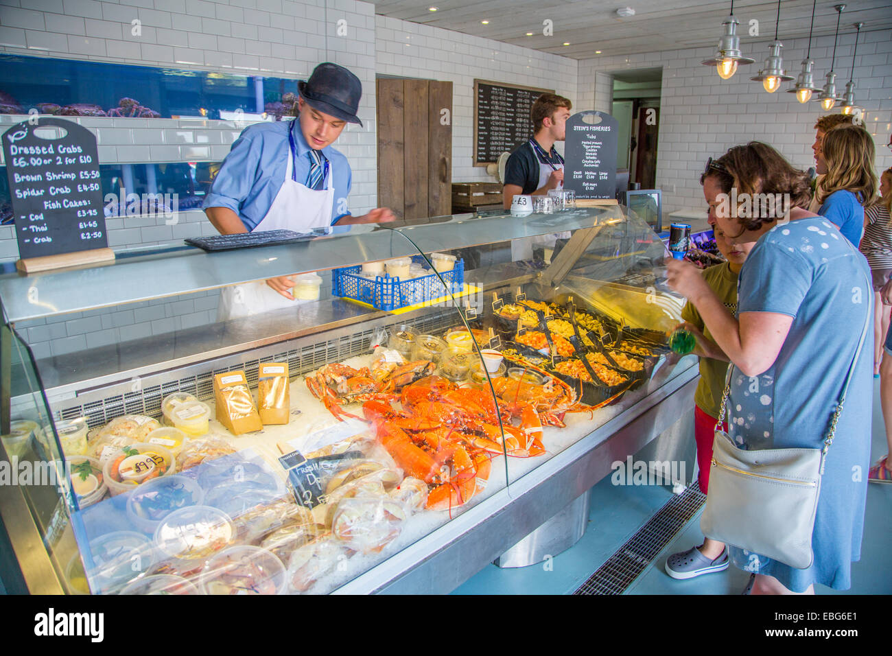 An Interior view of staff serving customers at Stein's Fisheries fresh fish counter Padstow Cornwall England UK Stock Photo