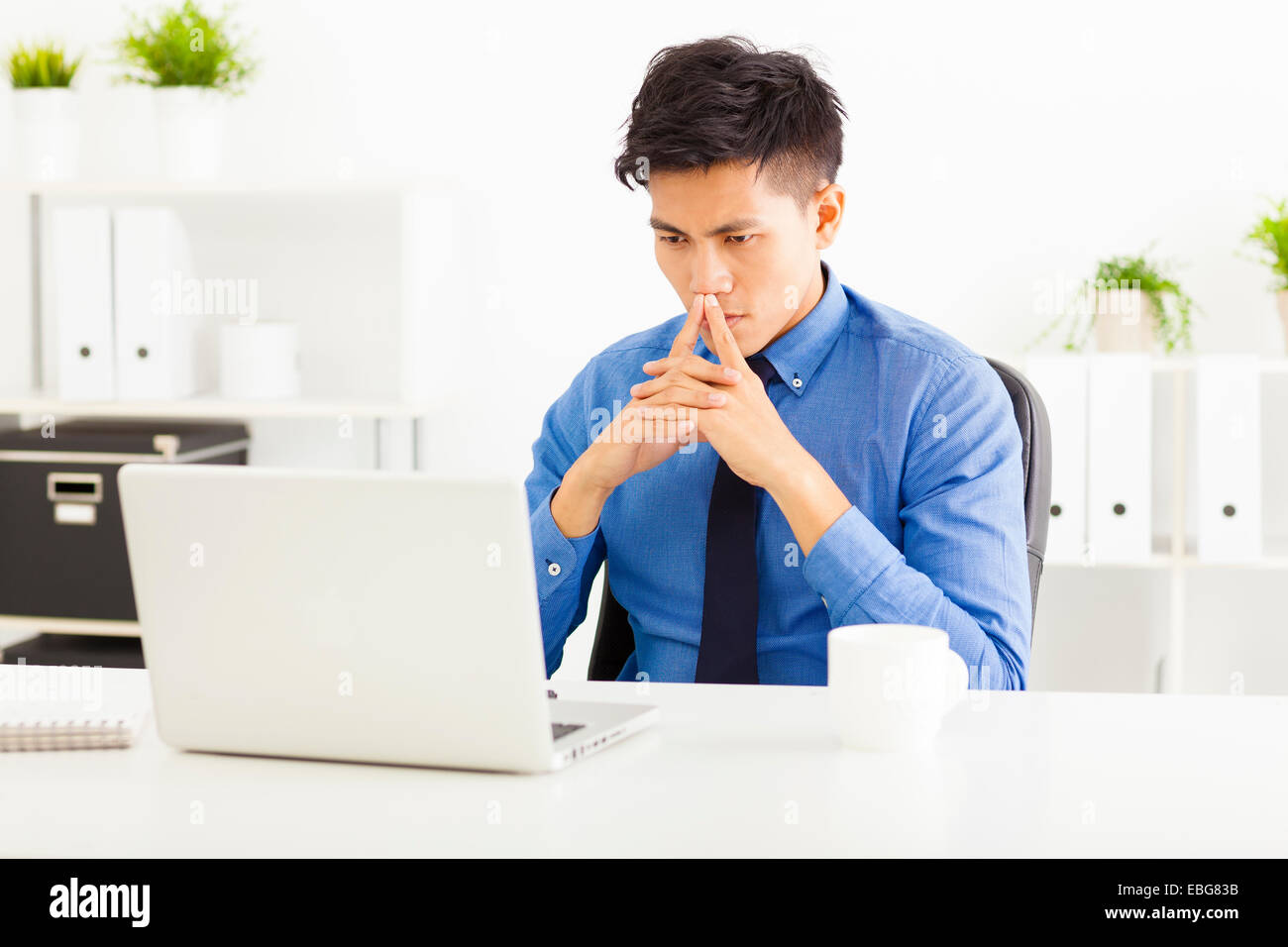 Young asian business man watching laptop and thinking Stock Photo