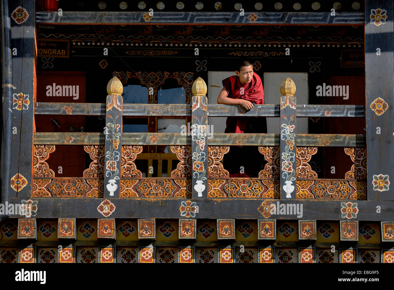 Buddhist monk leaning on a railing in Trongsa Dzong fortress, Trongsa ...