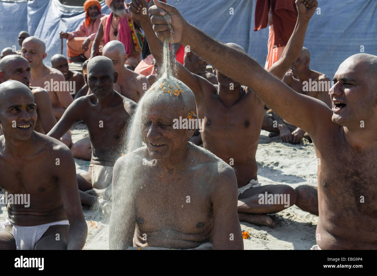 Man putting sand on the head of a another man joining the initiation of new sadhus, during Kumbha Mela festival, Allahabad Stock Photo