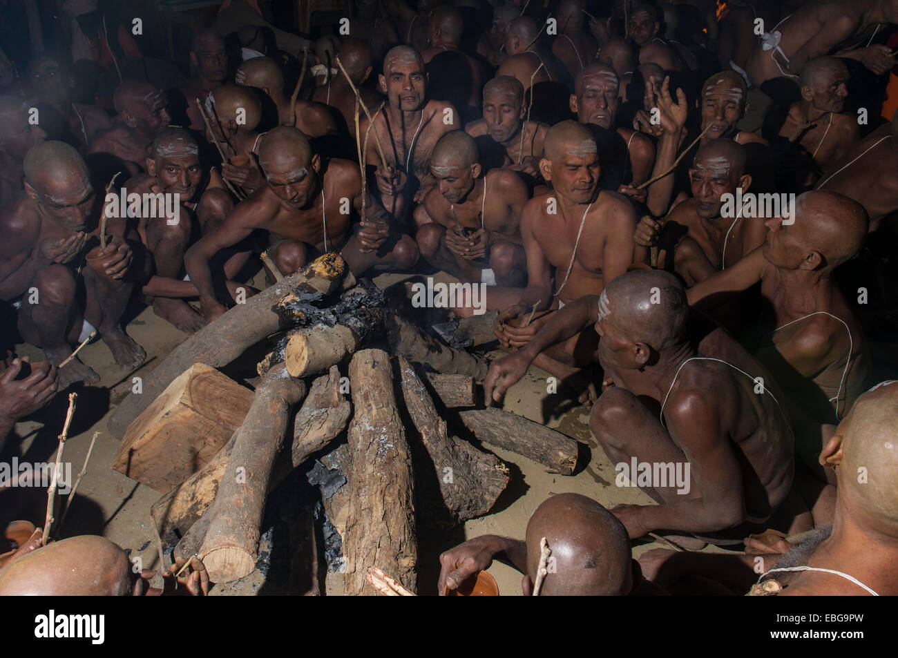 Sitting around a bonfire and chanting mantras as part of the initiation of new sadhus, during Kumbha Mela festival, Allahabad Stock Photo