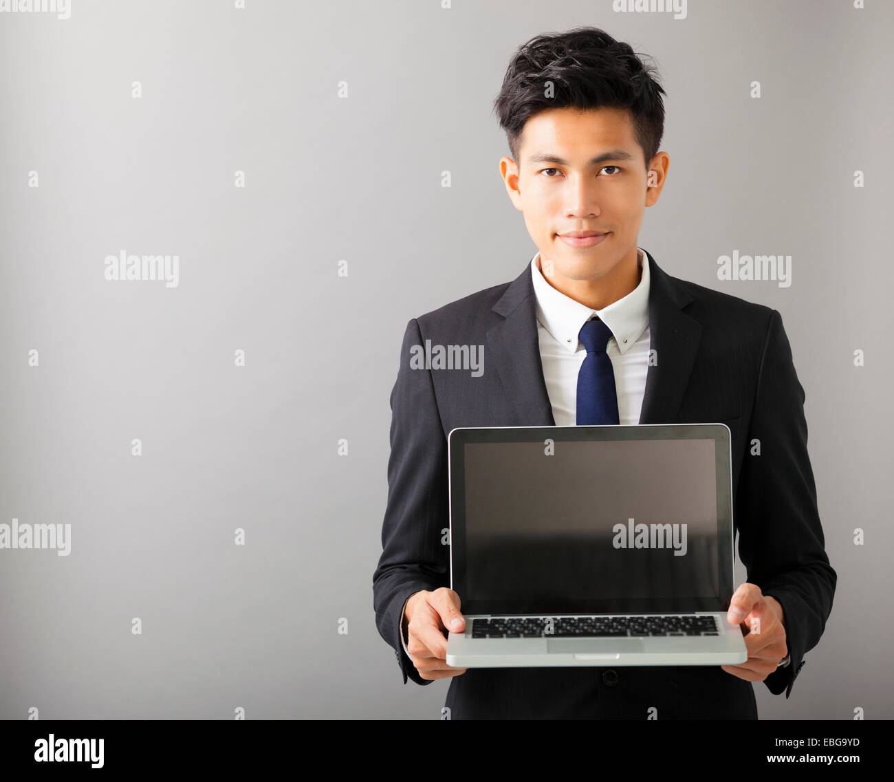 young smiling business man showing laptop Stock Photo