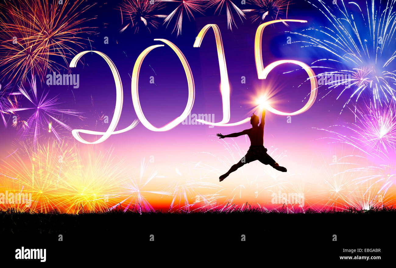 happy new year 2015 . young man jumping and drawing 2015 by flashlight Stock Photo