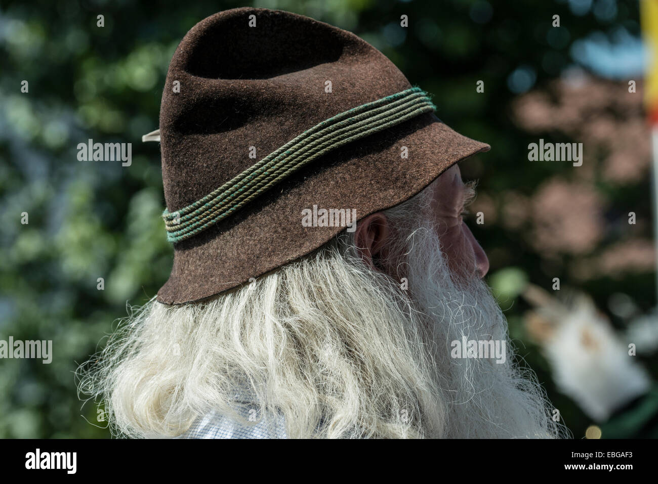 Old man with long gray hair and a traditional Bavarian hat, Oberlandler Gauverband Trachtenzug traditional costume procession Stock Photo