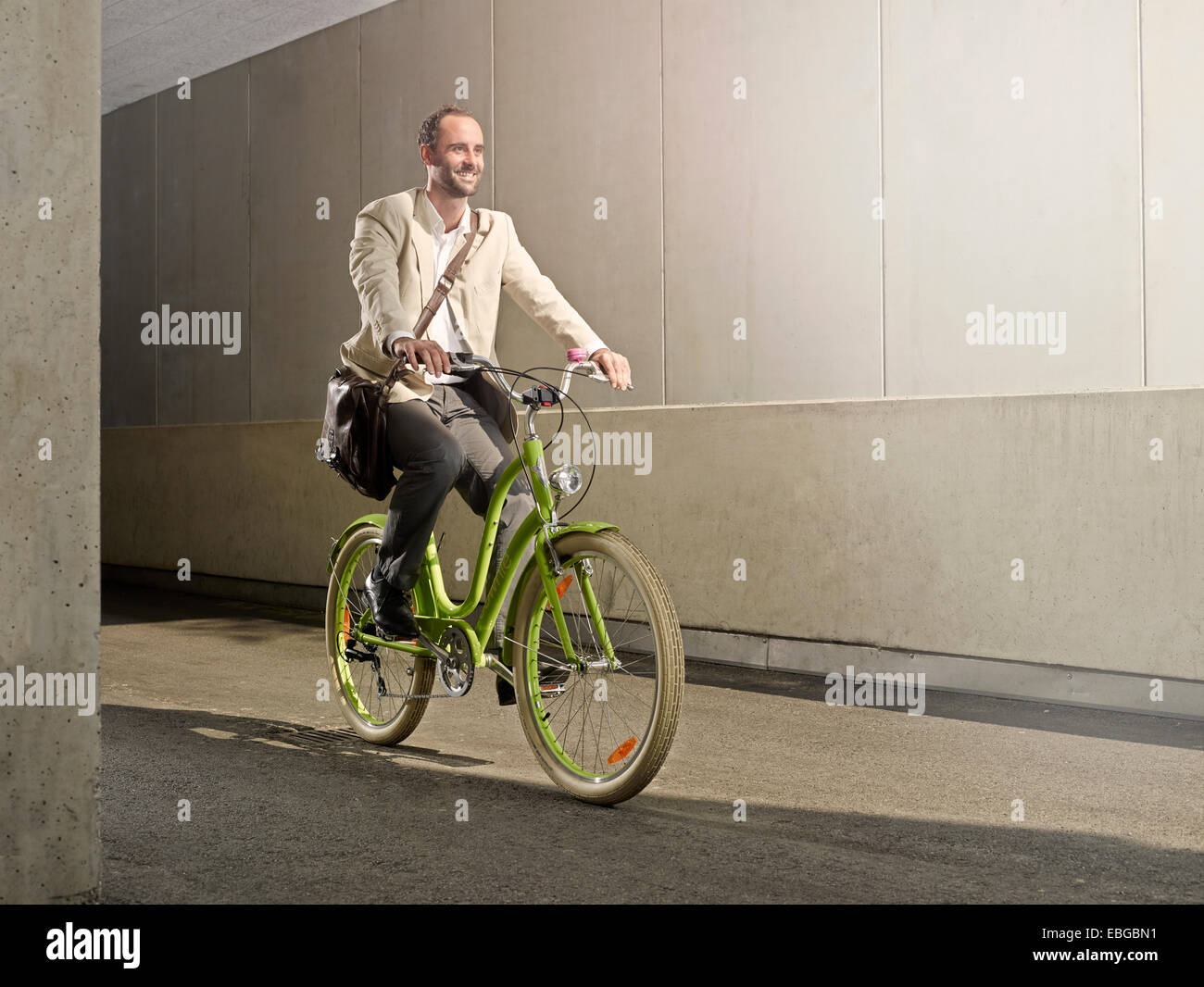 Man carrying a bag over his shoulder while riding a bicycle in the city