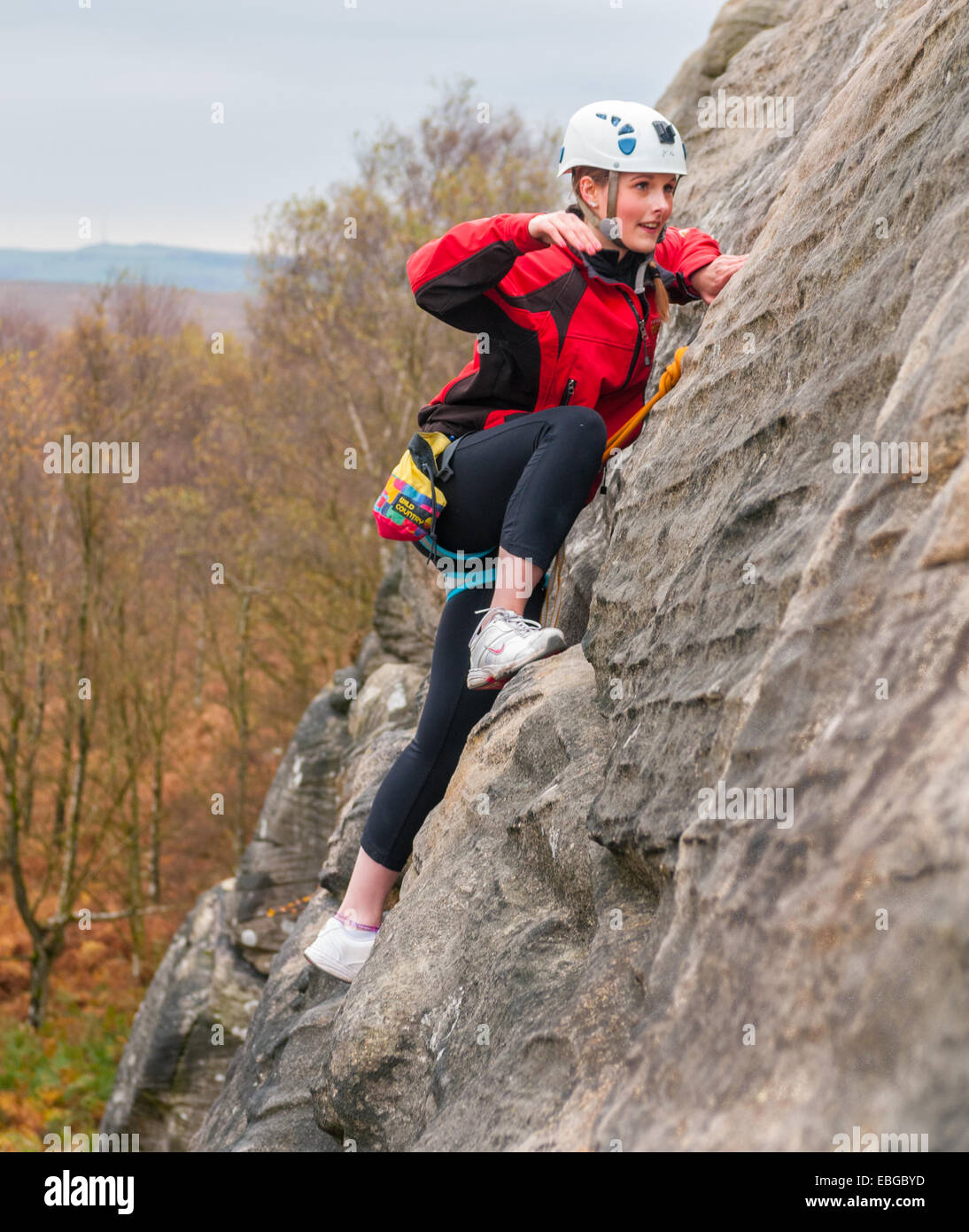 Young teenager girl rock climbing on Birchen Edge in The Peak District of Derbyshire Stock Photo