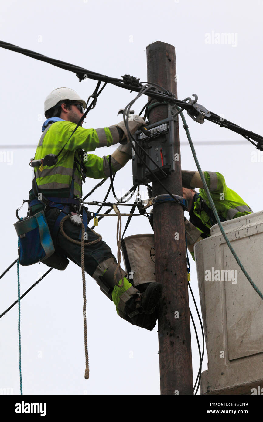 Two power supply workers replacing electric cables. Stock Photo