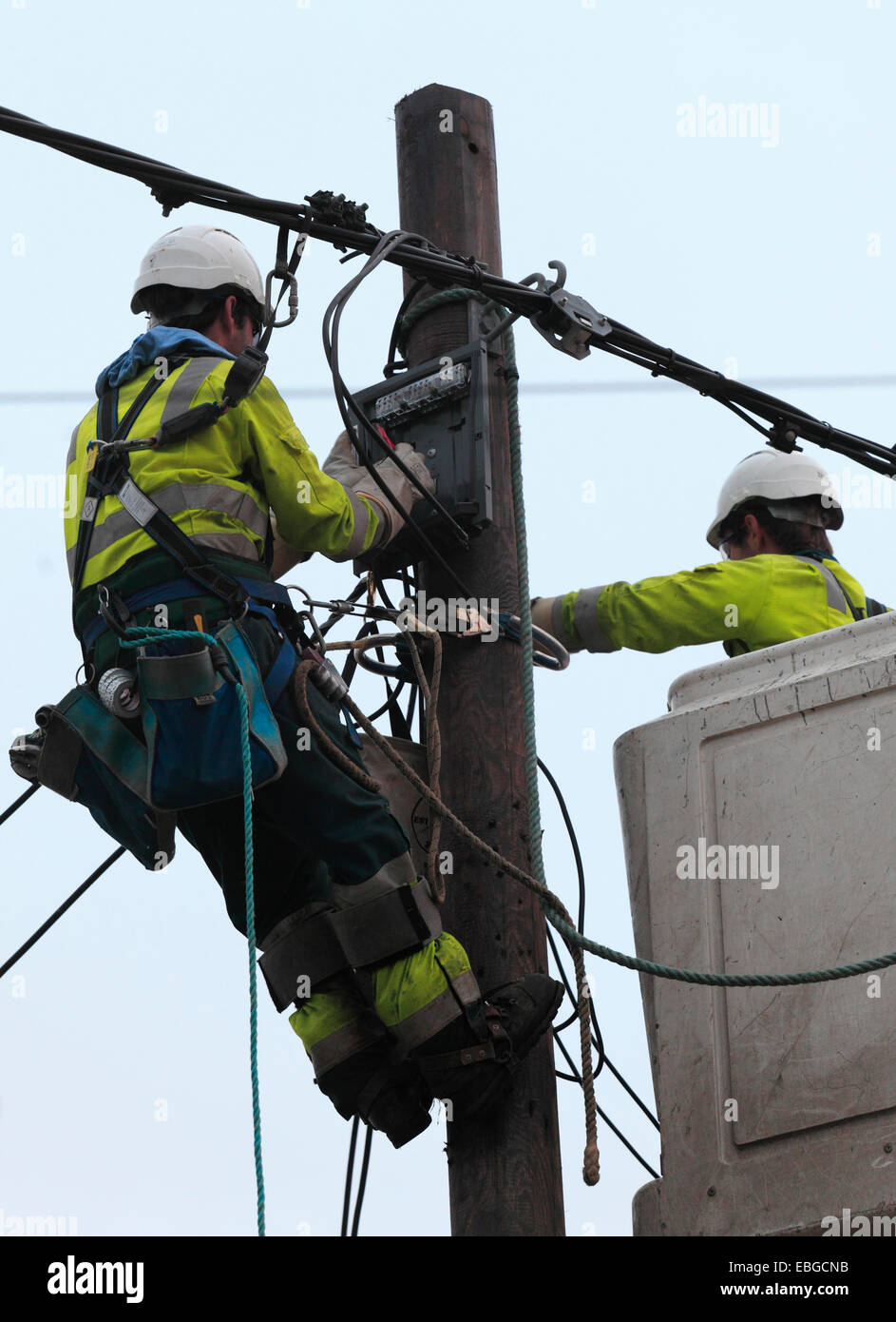 Two power supply workers replacing electric cables. Stock Photo