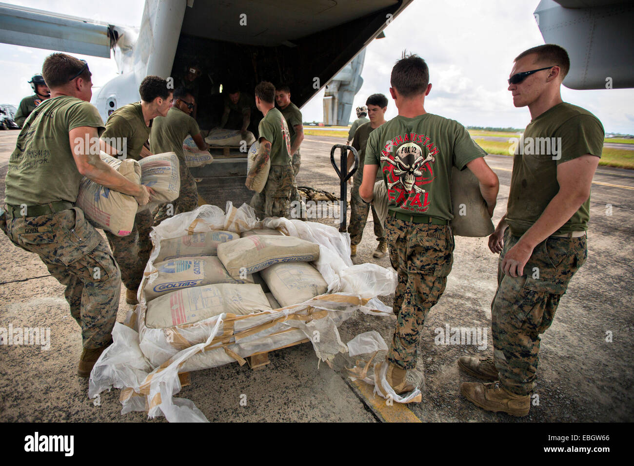 US Marines with Crisis Response Africa load bags of concrete, that will be used by local and international health organizations to build Ebola Treatment Units, into an MV-22B Osprey aircraft during Operation United Assistance November 21, 2014 in Monrovia, Liberia. Stock Photo