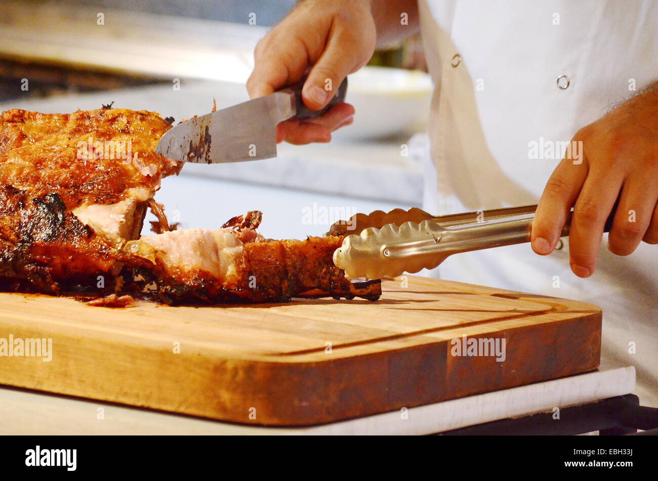 A chef cutting portions of roasted lamb ribs Stock Photo Alamy