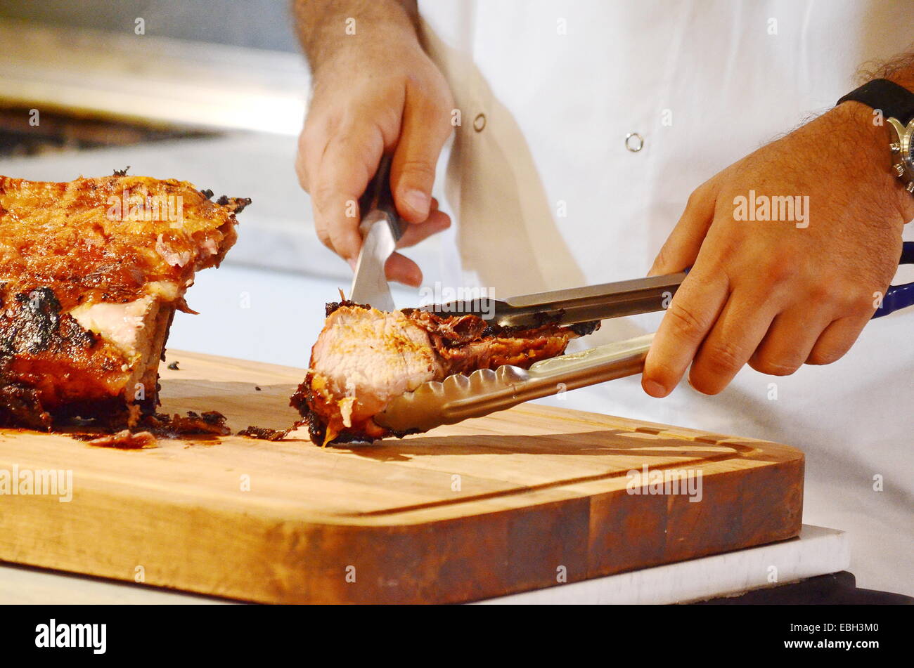 A chef cutting portions of roasted lamb ribs Stock Photo Alamy