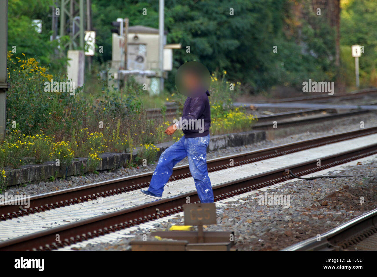 man crossing railtracks, Germany Stock Photo