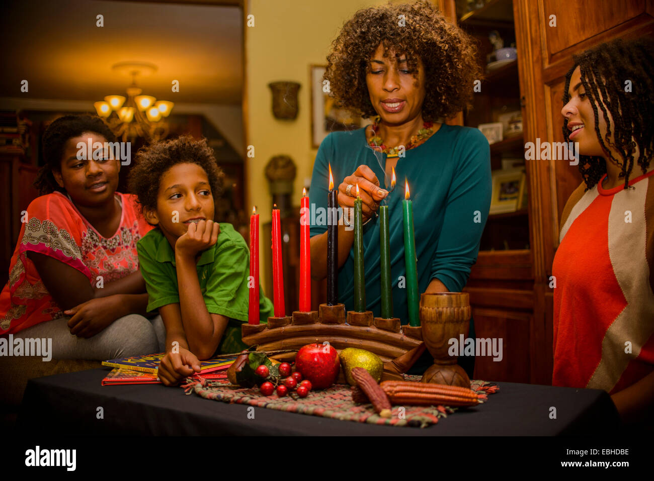 Family lighting kinara candles, celebrating Kwanzaa Stock Photo Alamy
