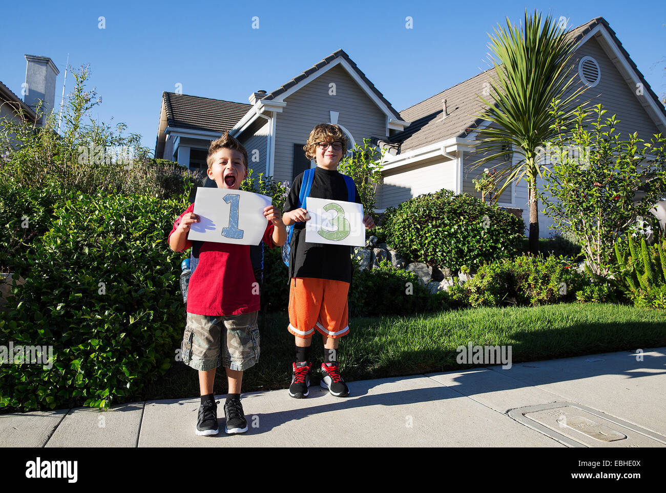 Portrait of two boys holding up pieces of paper with 1 & 3 Stock Photo