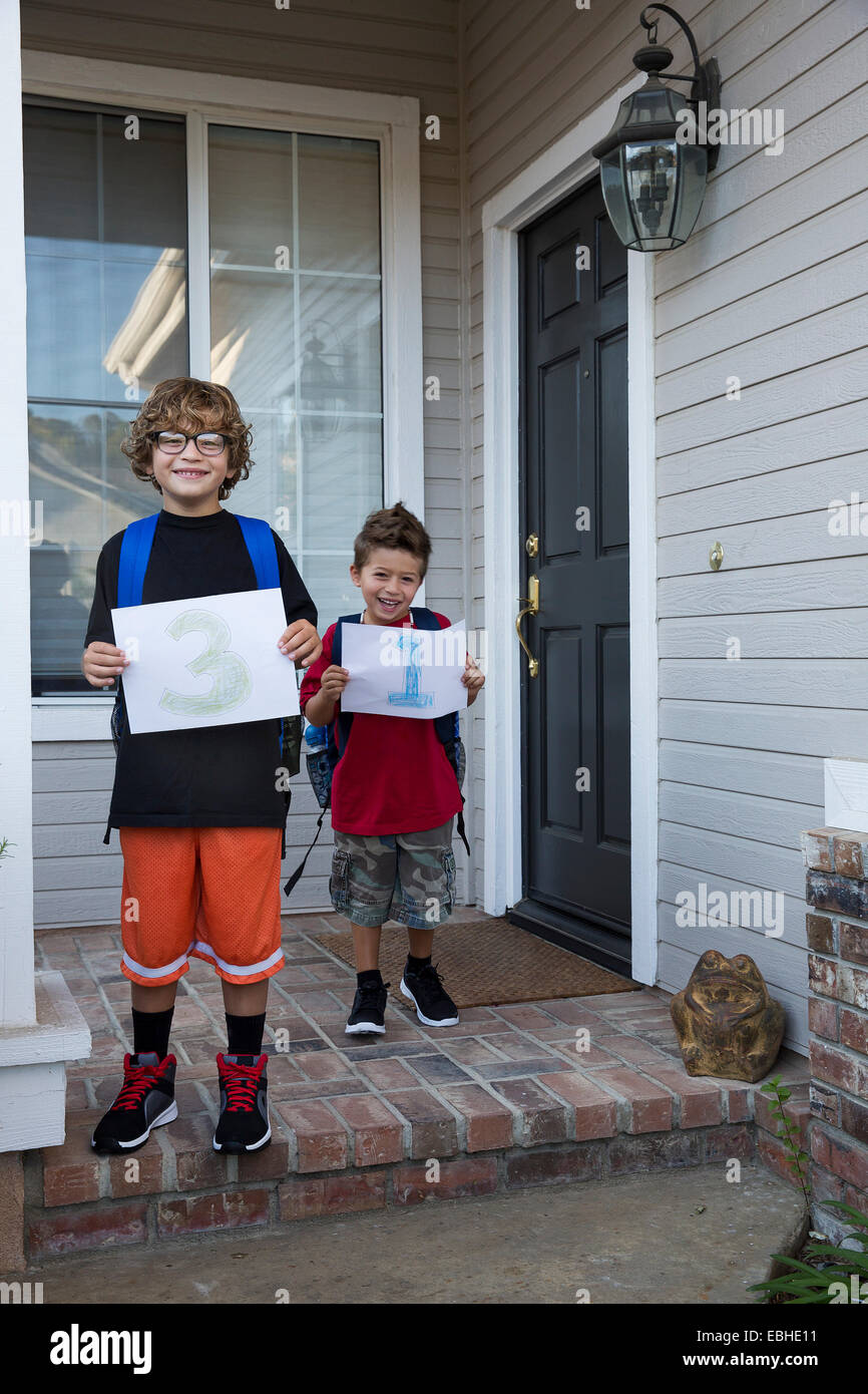 Portrait of two brothers holding up pieces of paper with 3 & 1 Stock Photo