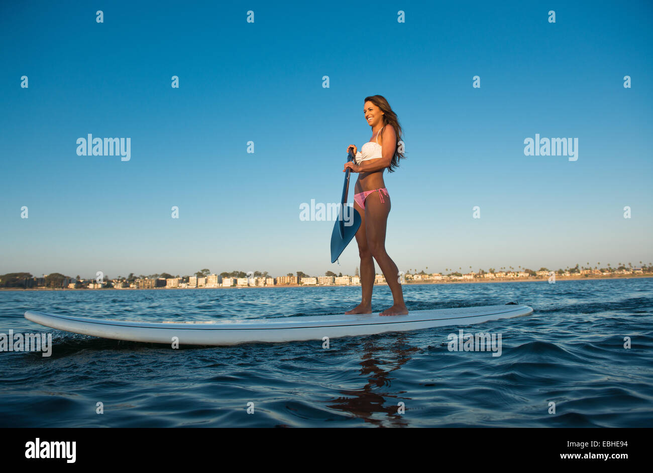 Young woman stand up paddleboarding, Mission Bay, San Diego, California, USA Stock Photo