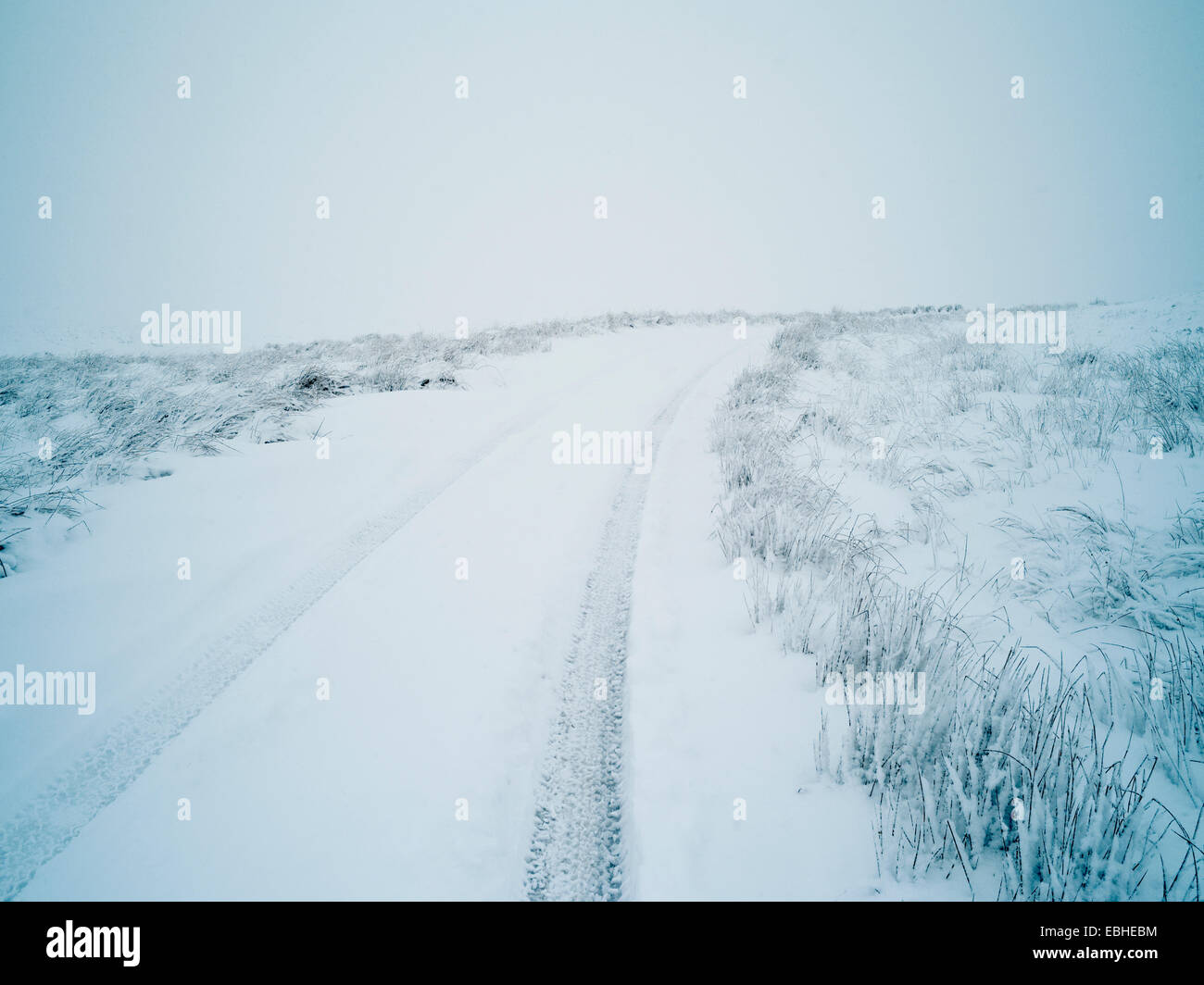 Car tracks through snow, Swaledale, Yorkshire, England, UK Stock Photo