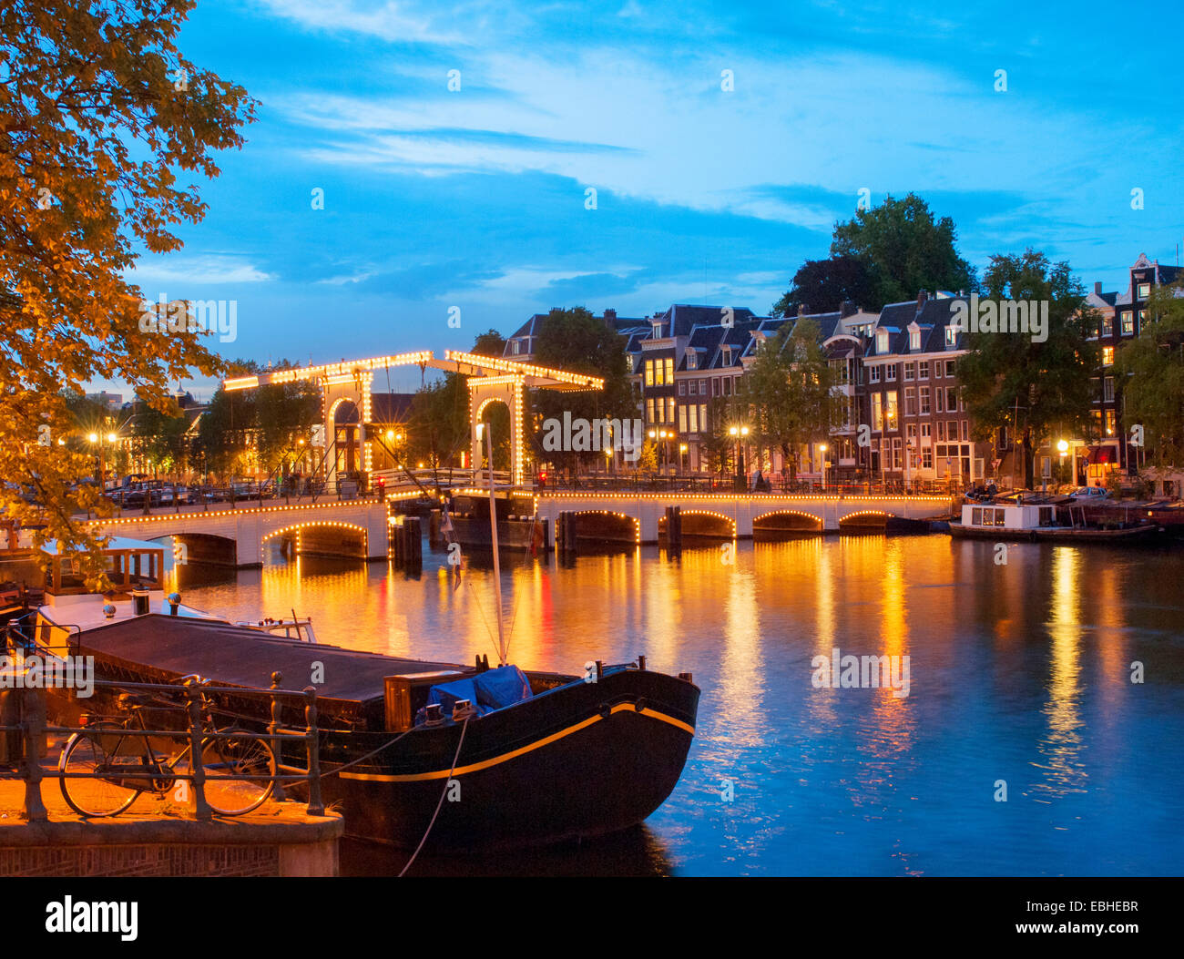 'The Skinny Bridge' illuminated at dusk, Amsterdam, Netherlands Stock Photo