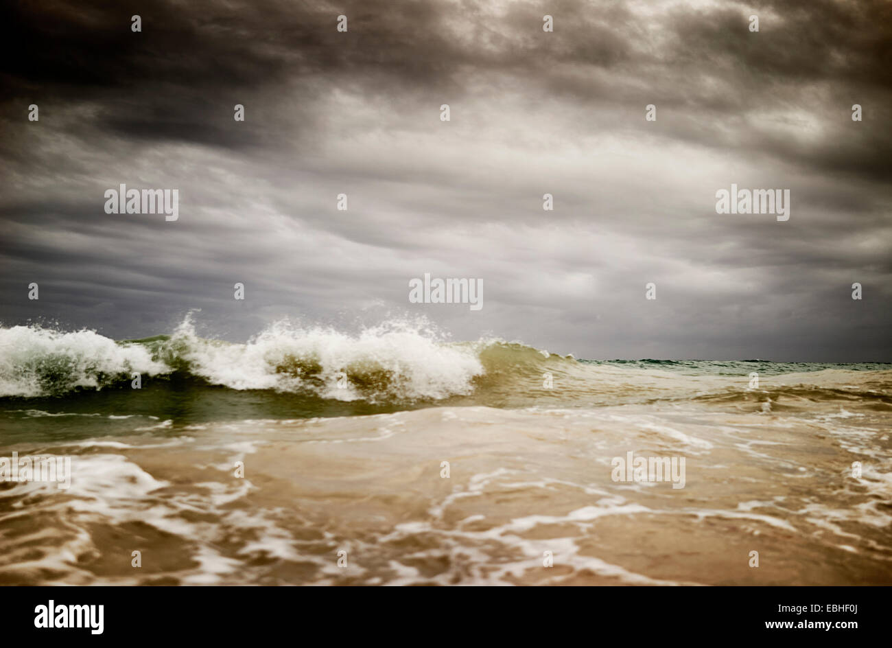 Storm clouds over splashing ocean waves Stock Photo