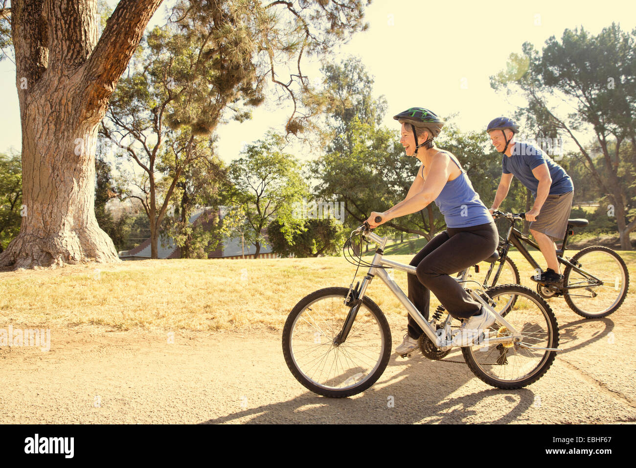 Mature couple cycling in park Stock Photo
