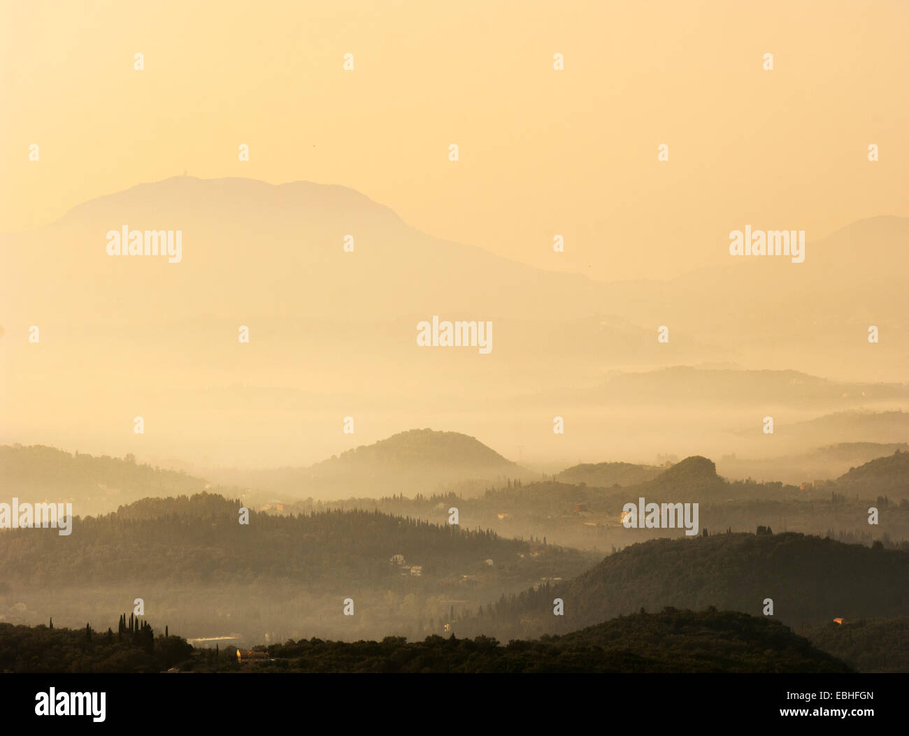Silhouetted misty valley at sunset, Sardinia, Italy Stock Photo