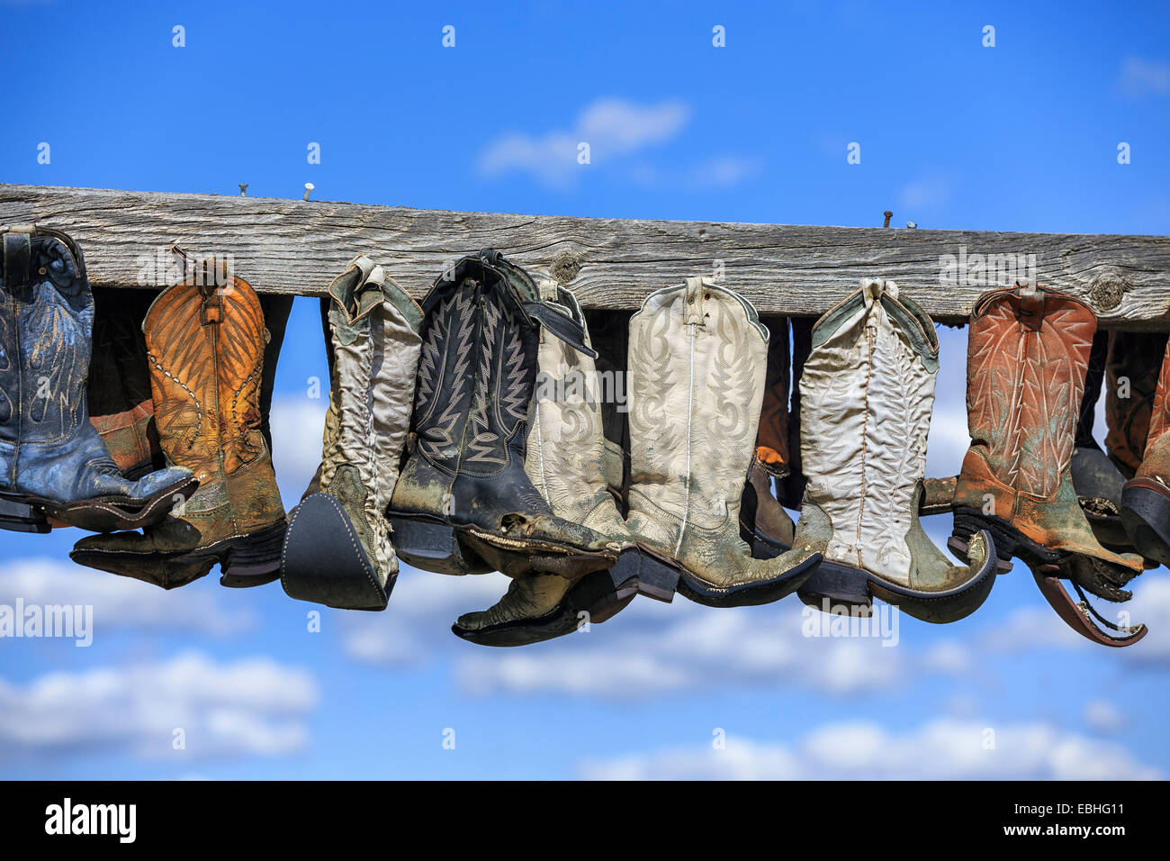 Old cowboy boots hanging on post, in memory of John Booth, Great Sandhills, near Sceptre, Saskatchewan, Canada Stock Photo