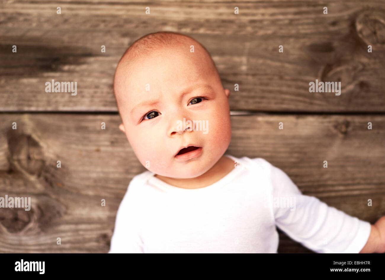 Overhead portrait of baby boy on wooden floor Stock Photo Alamy