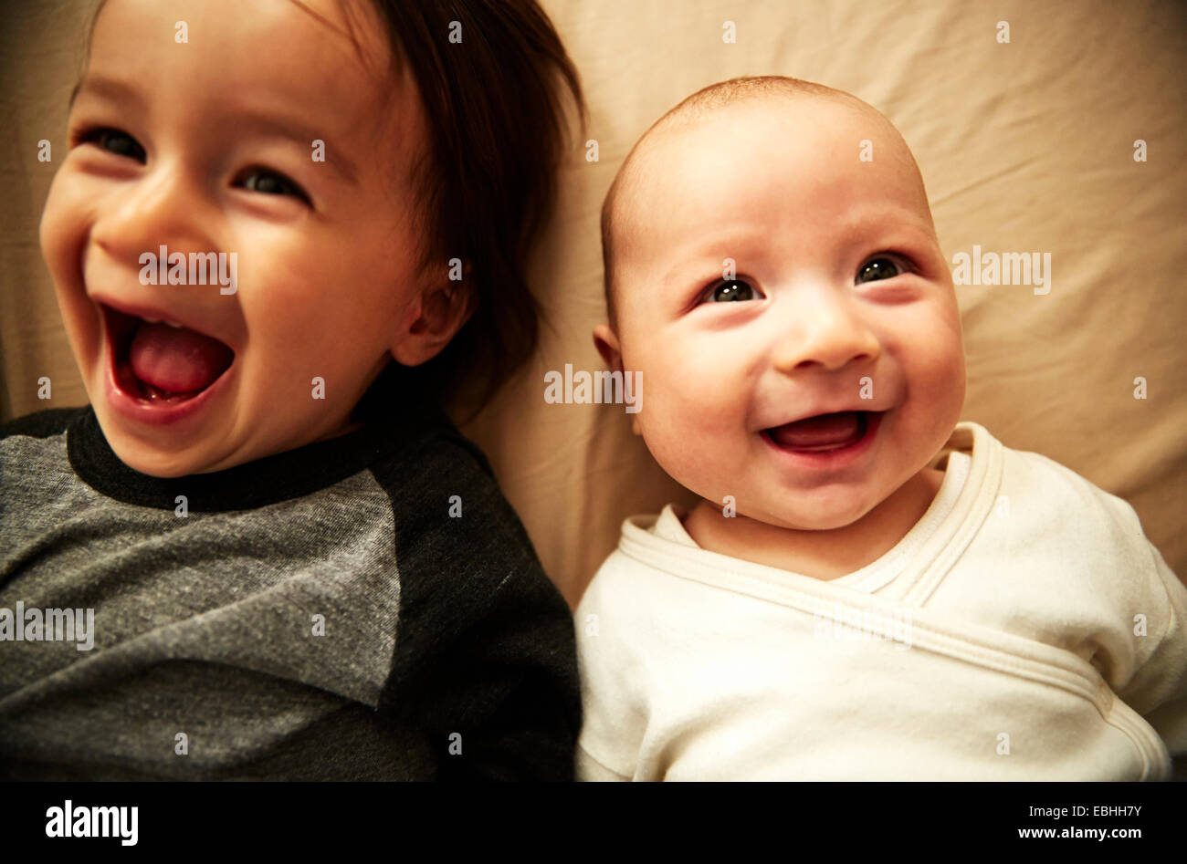 Overhead view of male toddler and baby brother laughing Stock Photo