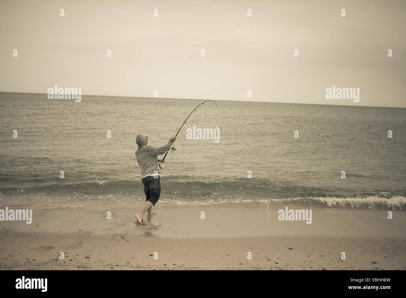 Fisherman casting fishing rod on beach, Truro, Massachusetts, Cape Cod, USA Stock Photo