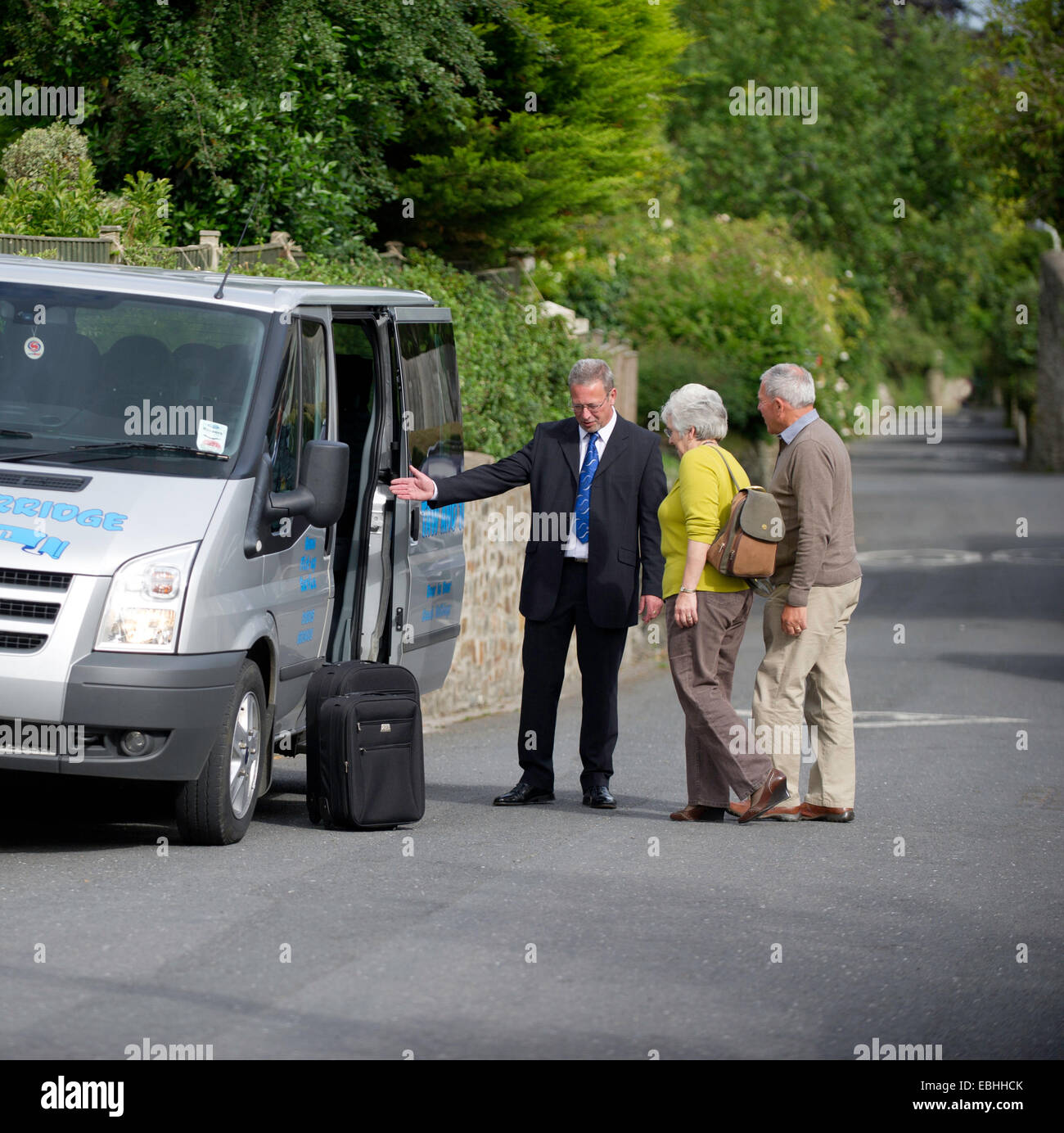 An older couple being collected from home at the start of their holiday Stock Photo