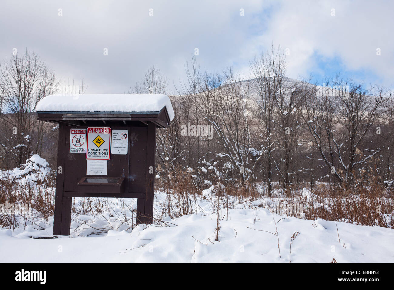 Information board shows trail warnings and rules at Mount Greylock State Park in Adams Massachusetts. Mount Greylock in rear. Stock Photo